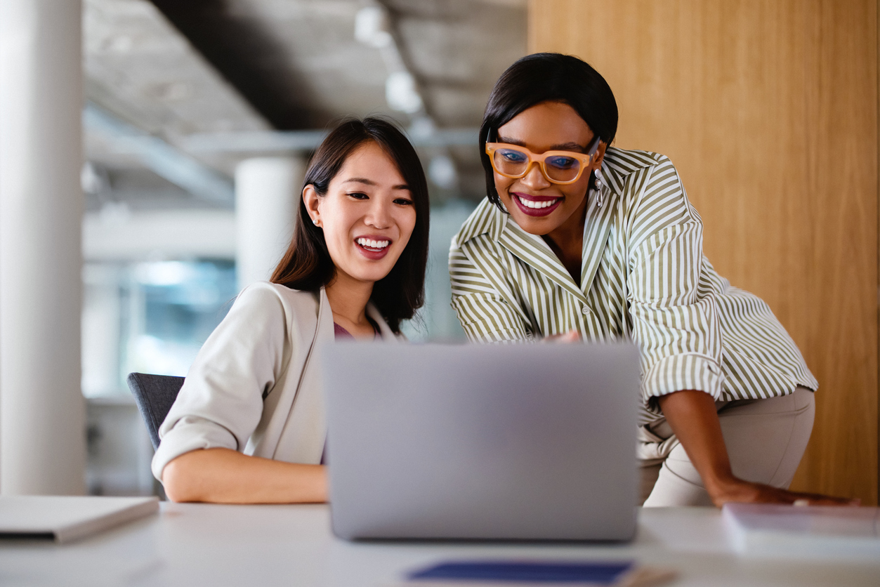 Two Professional Women Collaborating on a Project in Office